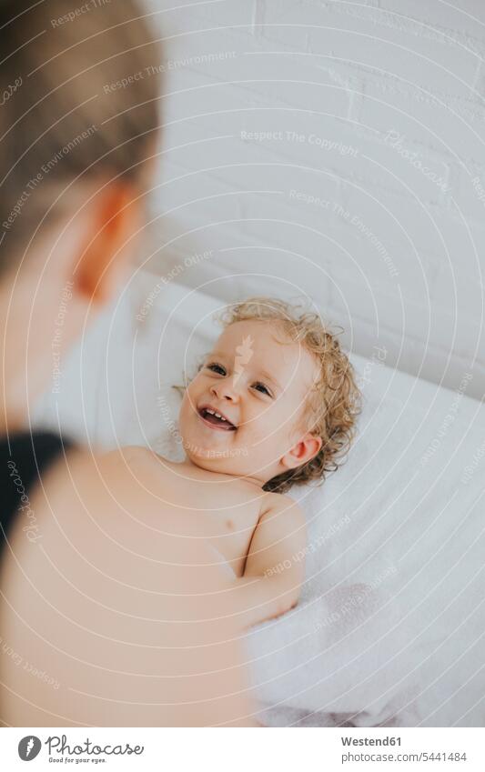 Little girl laughing at mother happiness happy daughter daughters relaxed relaxation lying laying down lie lying down female baby female babies Laughter child
