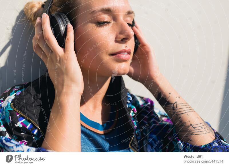 Portrait of young woman with eyes closed listening music with headphones females women headset portrait portraits Adults grown-ups grownups adult people persons