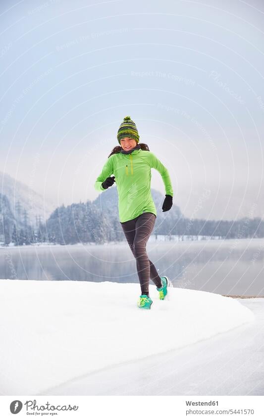 Germany, Bavaria, Lake Kochel, woman jogging in winter exercising exercise training practising running Jogging females women fitness sport sports Adults