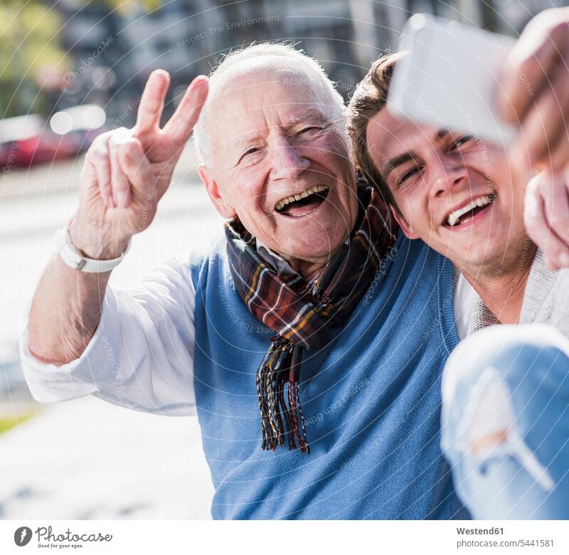 Happy senior man and adult grandson taking a selfie grandsons smiling smile Selfie Selfies happiness happy mobile phone mobiles mobile phones Cellphone