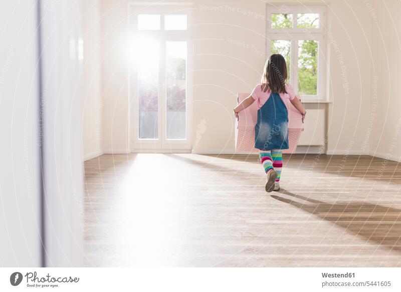 Girl carrying cardboard box in empty apartment girl females girls Cardboard Carton carton cardboard boxes Cardboards cartons flat flats apartments child
