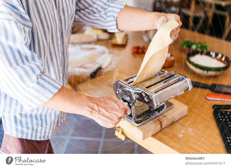 Woman rolling dough with pasta machine, partial view hand human hand hands human hands preparing Food Preparation preparing food Pasta people persons