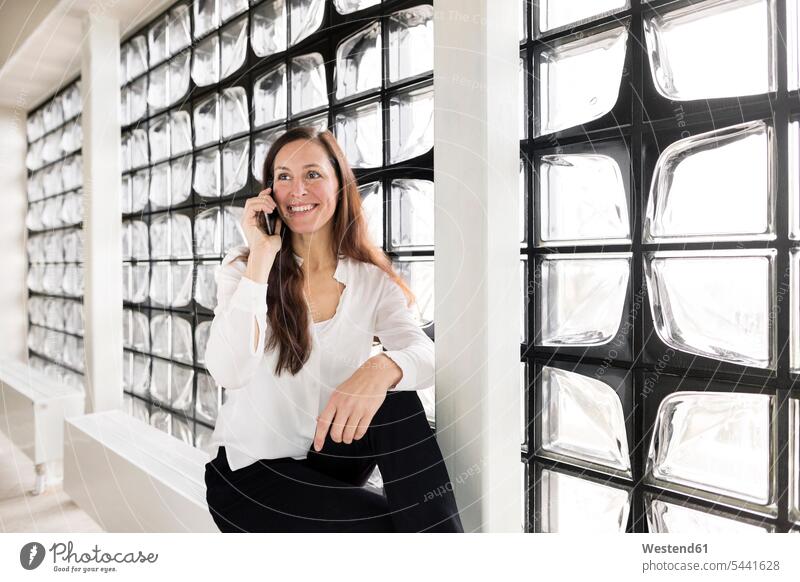 Portrait of smiling businesswoman on the phone females women portrait portraits call telephoning On The Telephone calling Adults grown-ups grownups adult people