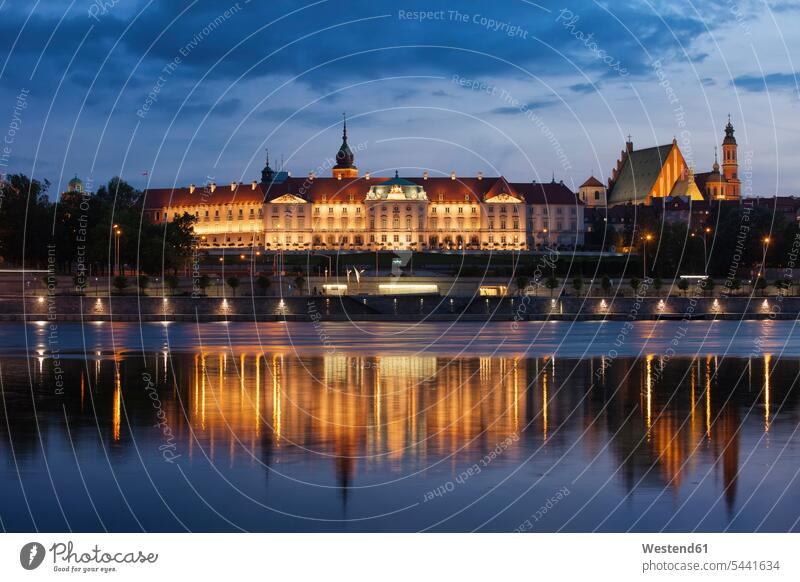 Poland, Warsaw, Royal Castle and Old Town skyline at dusk, reflection on Vistula River illuminated lit lighted Illuminating water reflection water reflections