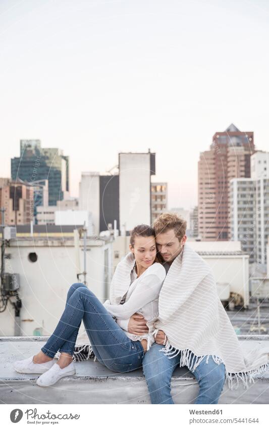 Romantic couple sitting on rooftop terrace, enjoying the view roof terrace deck happiness happy flirting Flirtation Seated parapet balustrade Falling In Love