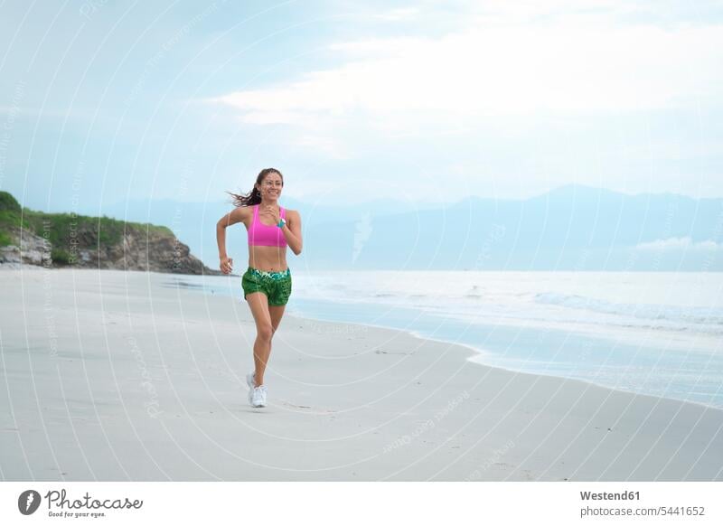 Woman running on the beach exercising exercise training practising jogger joggers female jogger fit beaches sportive sporting sporty athletic woman females