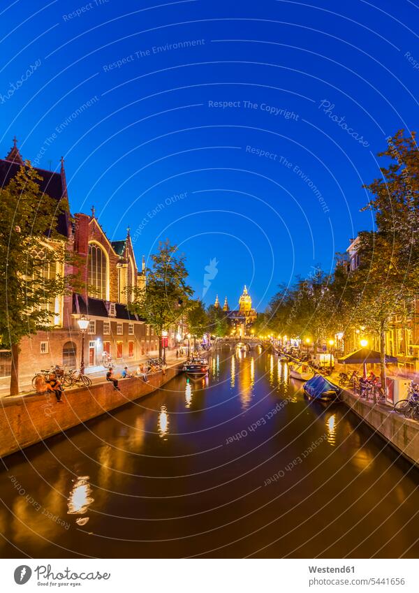 Netherlands, Amsterdam, De Wallen, Oudezijds Voorburgwal, Oude Kerk and town canal and evening twilight boat boats Christianity copy space idyllic quaint