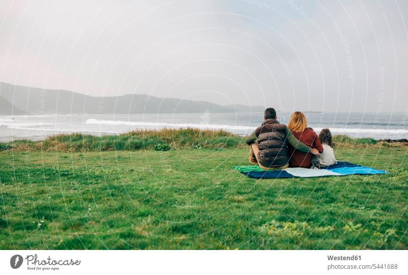 Back view of family with dog sitting on blanket at the coast coastline shoreline Blanket Blankets families dogs Canine people persons human being humans