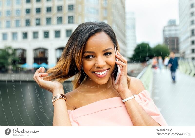 Smiling woman talking on the phone in the city mobile phone mobiles mobile phones Cellphone cell phone cell phones smiling smile call telephoning