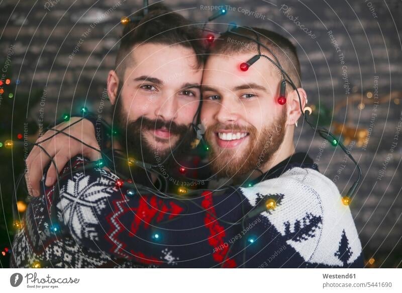 Portrait of happy gay couple with chain of lights at Christmas time Gay Couple Gays portrait portraits same-sex couple woman and woman women and women