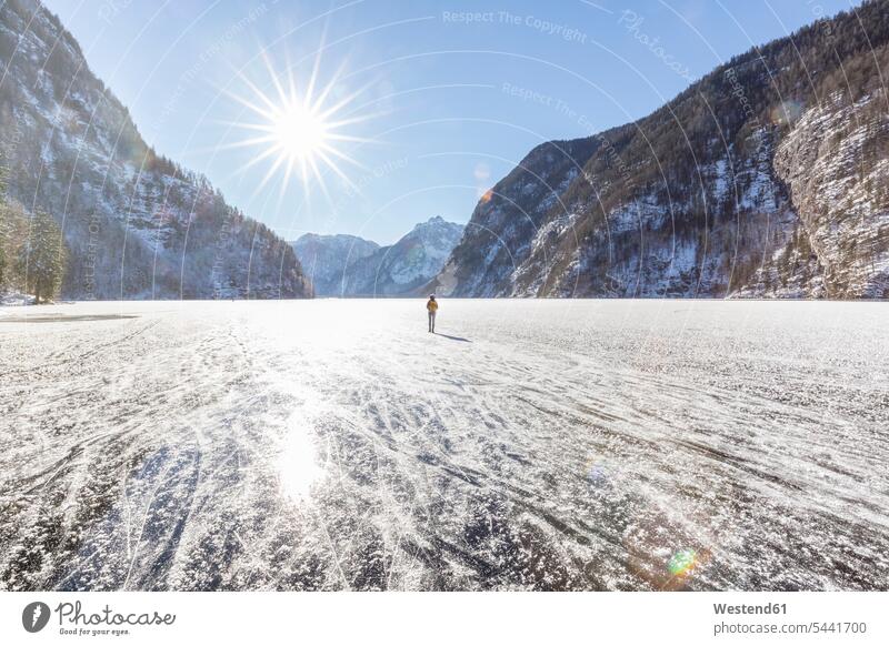 Germany, Berchtesgadener Land, back view of woman with backpack standing on frozen Lake Koenigssee females women Adults grown-ups grownups adult people persons
