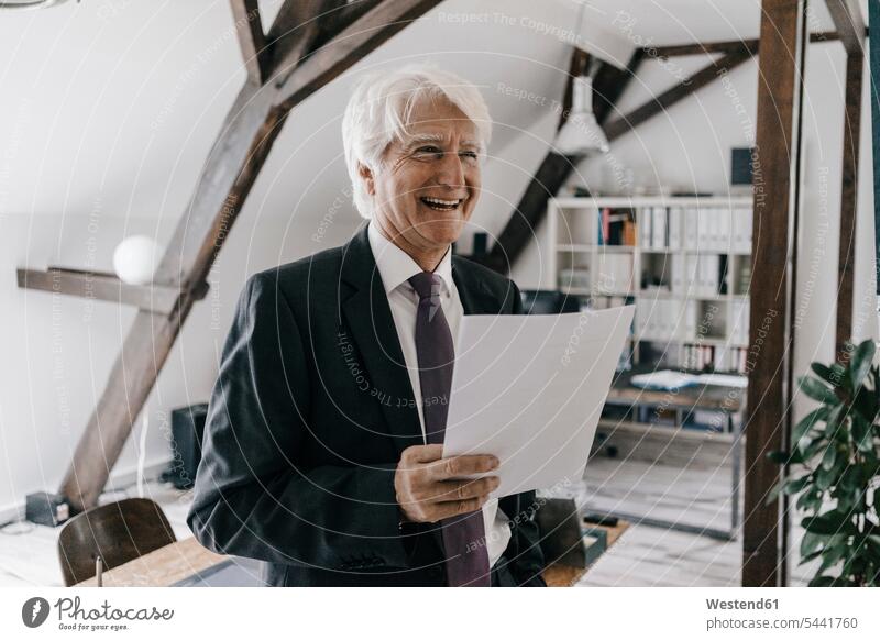Portrait of smiling senior businessman with document in his office Businessman Business man Businessmen Business men business people businesspeople