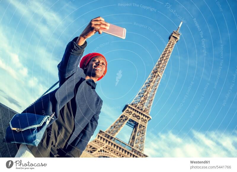 France, Paris, young woman taking selfie in front of Eiffel Tower Selfie Selfies females women Ile-de-France Adults grown-ups grownups adult people persons