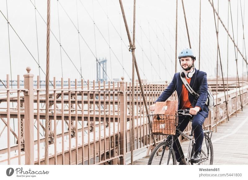 USA, New York City, man on bicycle on Brooklyn Bridge bikes bicycles New York State bridge bridges men males transportation United States