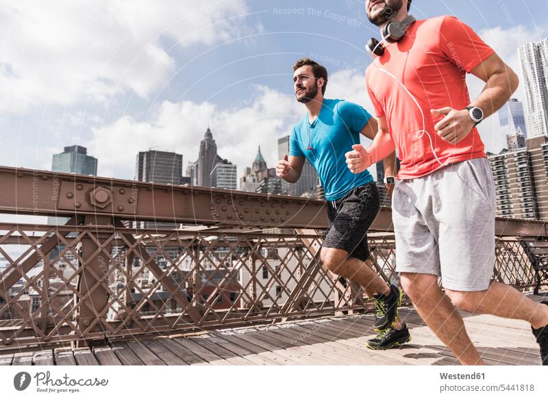 USA, New York City, two men running on Brooklyn Brige headphones headset Jogging man males bridge bridges fitness sport sports Adults grown-ups grownups adult