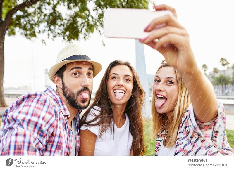 Three friends taking a selfie sticking tongues out mate Fun having fun funny mobile phone mobiles mobile phones Cellphone cell phone cell phones Selfie Selfies