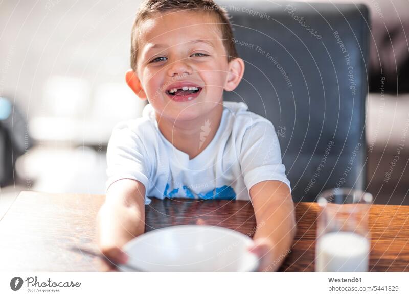 Portrait of smiling boy at dining table smile boys males portrait portraits home at home child children kid kids people persons human being humans human beings