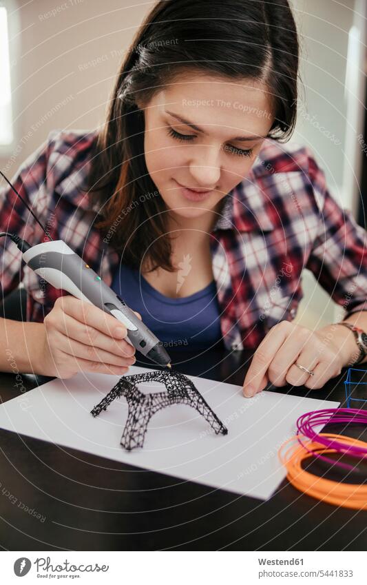 Young woman drawing Eiffel Tower with 3D pen females women 3D Pen three dimensional Three-Dimensional Shape 3-d 3D printer 3D printers sketching pencils pens