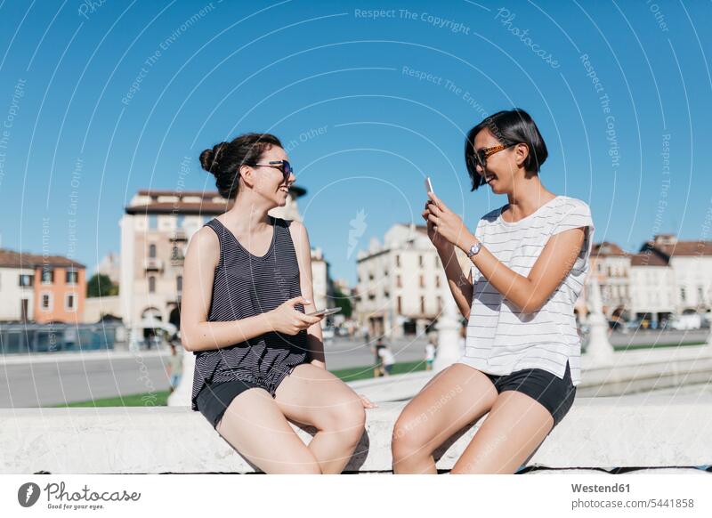 Italy, Padua, young woman taking picture of her friend with smartphone female friends Smartphone iPhone Smartphones photographing mate friendship mobile phone