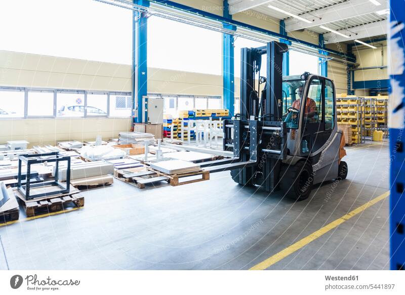 Man on forklift in factory warehouse working At Work worker blue collar worker workers blue-collar worker storehouse storage man men males forklifts