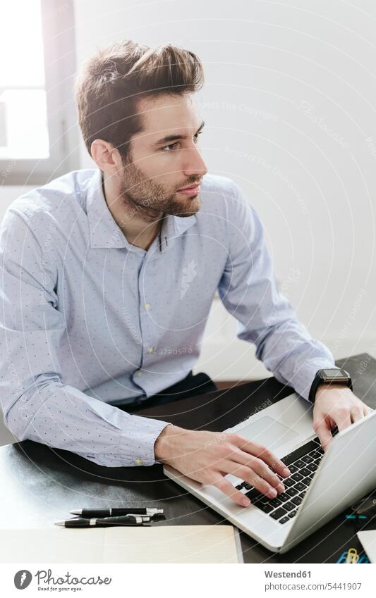 Young businessman working in office, using laptop typing type using a laptop Using Laptops At Work Laptop Computers laptops notebook ballpen ball-pens ballpens