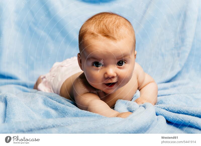 Portrait of smiling baby girl lying on light blue blanket portrait portraits laying down lie lying down Blanket Blankets infants nurselings babies baby girls