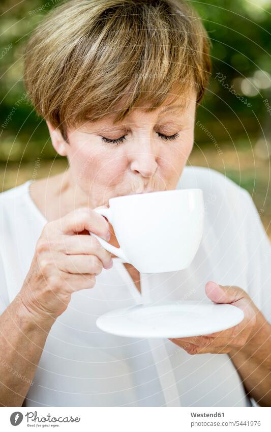 Senior woman drinking cup of coffee outdoors - a Royalty Free Stock Photo  from Photocase