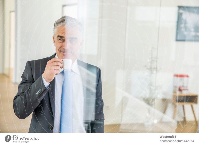 Mature businessman standing in office, drinking coffee Businessman Business man Businessmen Business men Coffee Success successful offices office room