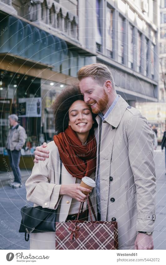 Happy couple shopping in the city twosomes partnership couples smiling smile embracing embrace Embracement hug hugging people persons human being humans