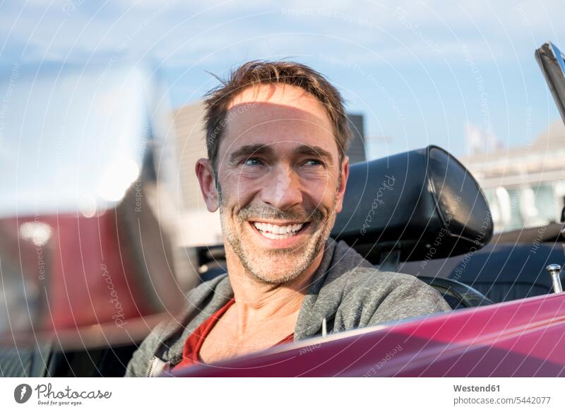 Portrait of smiling mature man sitting in his sports car portrait portraits men males convertible Adults grown-ups grownups adult people persons human being