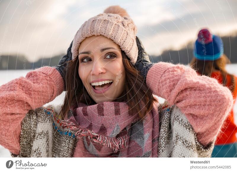 Happy woman holding her woolen hat woolly hat Wooly Hat Knit-Hat Knit Hats wool cap happiness happy females women smiling smile hats caps Adults grown-ups
