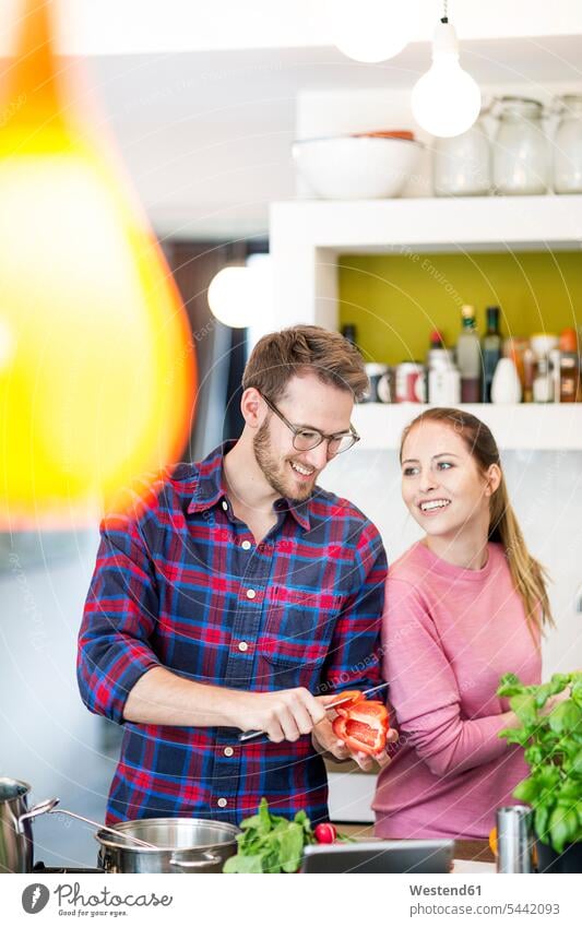Happy young couple preparing healthy meal in kitchen cooking happiness happy Food Preparation preparing food Meals twosomes partnership couples preparation