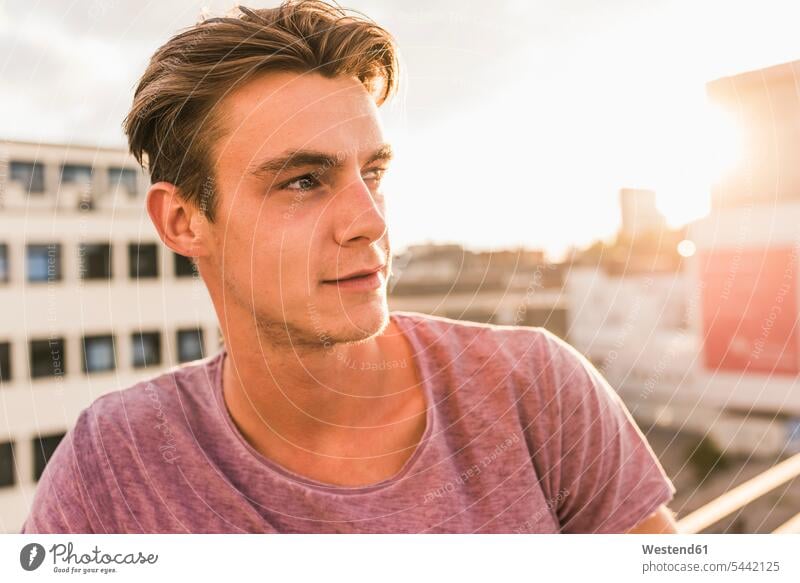 Portrait of young man on rooftop at sunset roof terrace deck sunsets sundown men males portrait portraits atmosphere atmospheric mood moody Atmospheric Mood