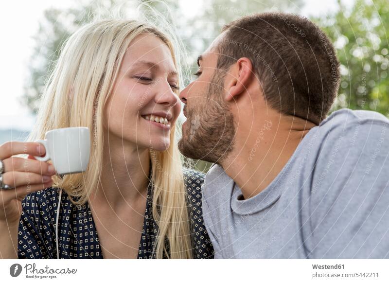 Kissing couple in love in the morning twosomes partnership couples people persons human being humans human beings Espresso looking eyeing happiness happy