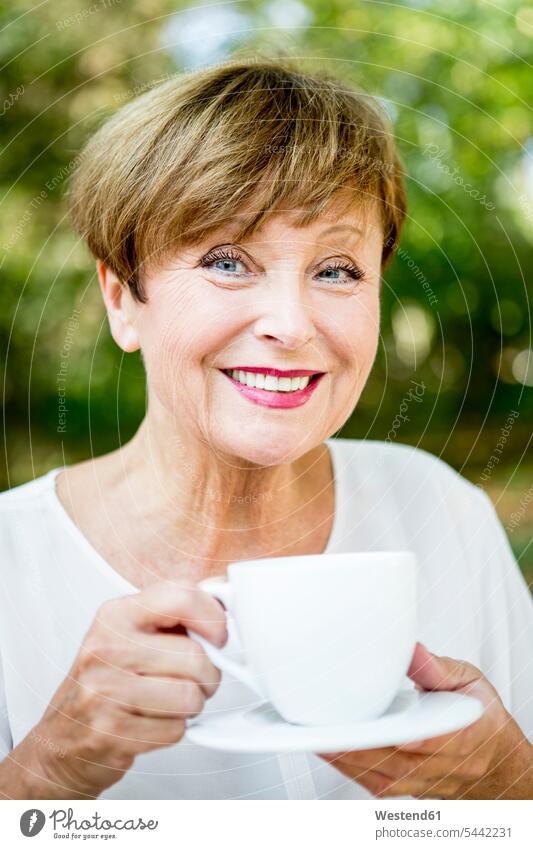 Portrait of smiling senior woman drinking cup of coffee outdoors Coffee smile females women Drink beverages Drinks Beverage food and drink Nutrition
