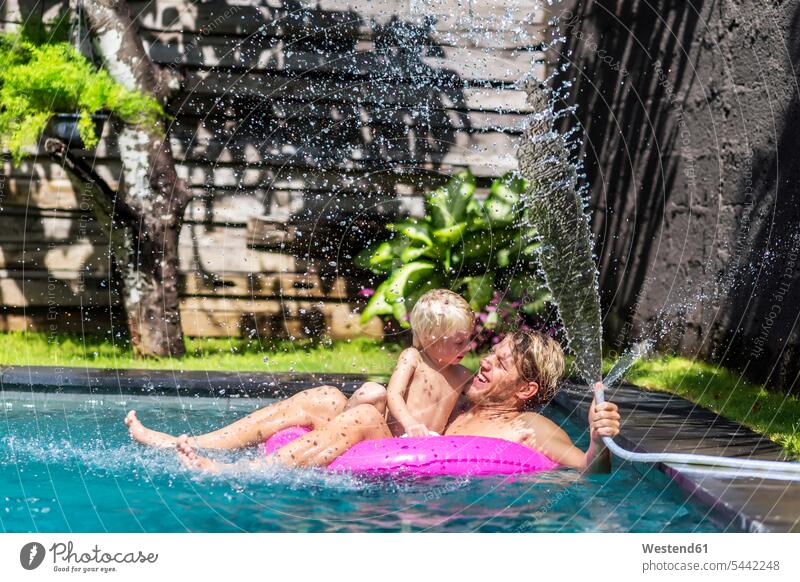 Father and little son having fun together in the swimming pool father pa fathers daddy papa pools swimming pools sons manchild manchildren parents family