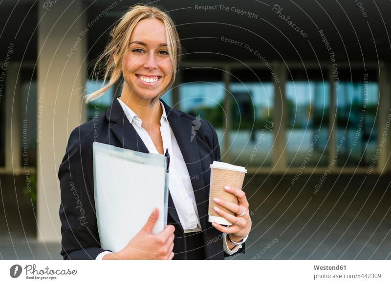 Portrait of happy businesswoman with documents and coffee to go portrait portraits businesswomen business woman business women business people businesspeople
