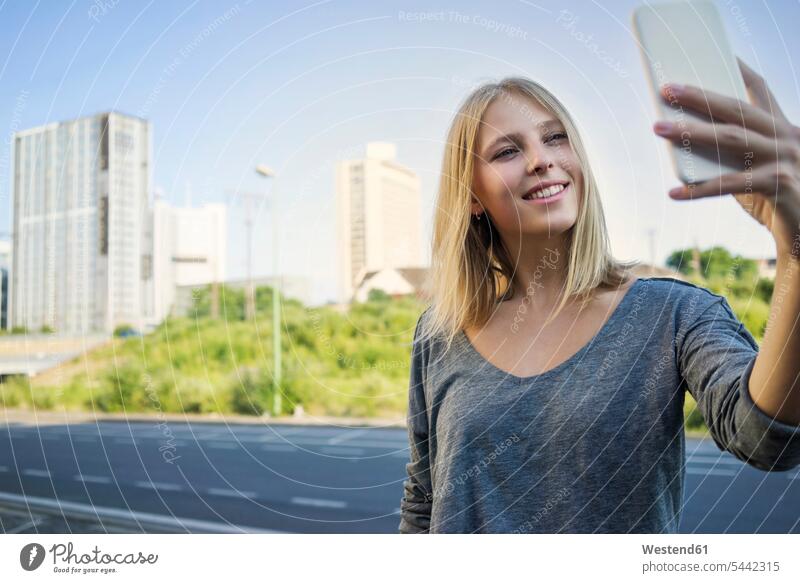 Portrait of smiling young woman taking selfie with smartphone females women Smartphone iPhone Smartphones smile Selfie Selfies portrait portraits Adults
