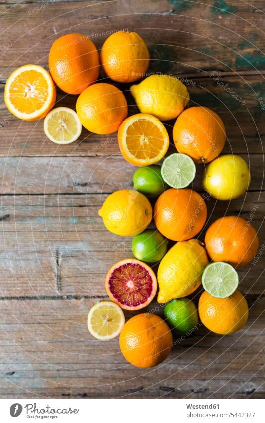 Sliced and whole lemons, oranges and limes on wood rich in vitamines various different circle circles circular sort sorts healthy eating nutrition abundance