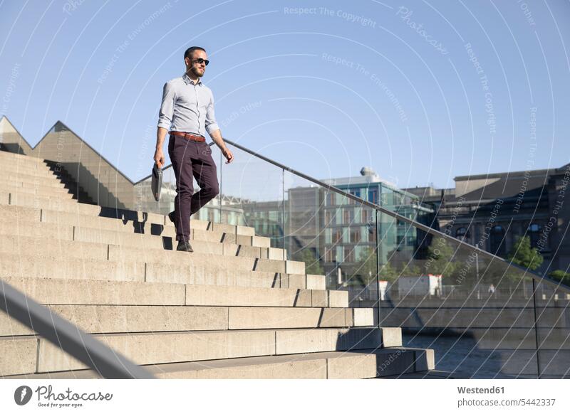 Businessman wearing sunglasses walking downstairs city town cities towns Business man Businessmen Business men stairway going outdoors outdoor shots
