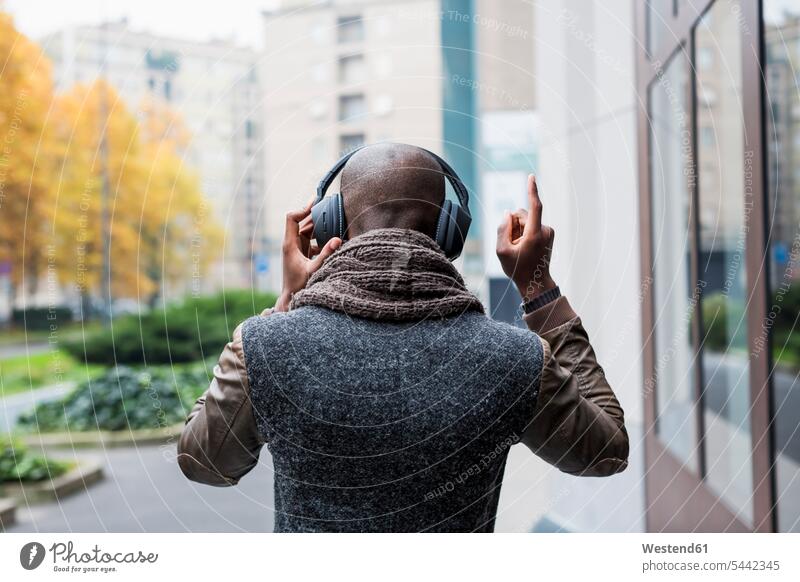 Back view of bald man listening music with headphones headset men males Adults grown-ups grownups adult people persons human being humans human beings autumn