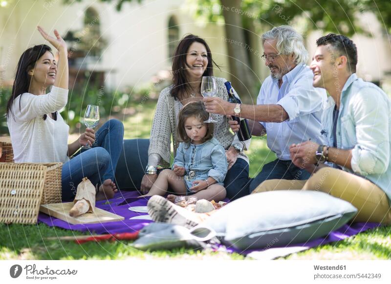 Happy extended family having a picnic families Wine generations Picnic picnicking people persons human being humans human beings Alcohol alcoholic beverage