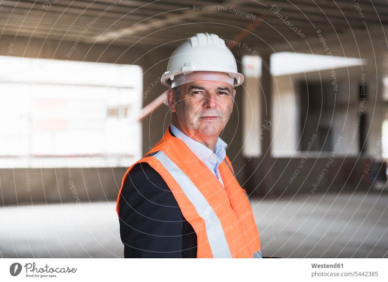Portrait of man wearing safety vest in building under construction men males architect architects construction site Building Site sites Building Sites