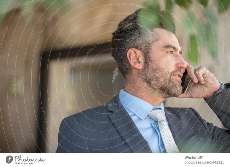 Businessman talking on cell phone on the phone call telephoning On The Telephone calling Business man Businessmen Business men mobile phone mobiles