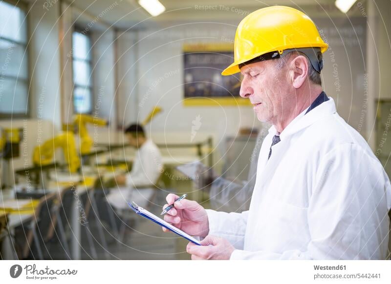 Engineer in factory with clipboard factories engineer engineers technology technologies engineering industry industrial security safe Safety secure company firm