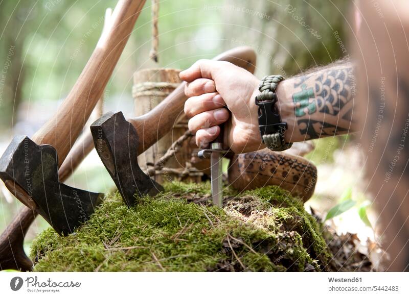 Axes, tree stump and hand holding knife in the forest man men males Tree Stump Tree Stumps axe woods forests tattoo tattoos knives Adults grown-ups grownups