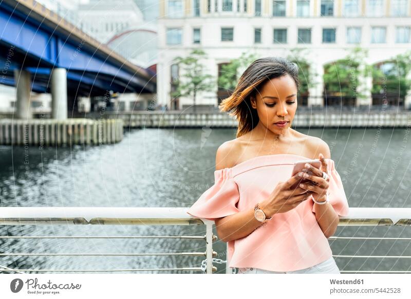 Woman sending messages with her smartphone in the city woman females women mobile phone mobiles mobile phones Cellphone cell phone cell phones Adults grown-ups