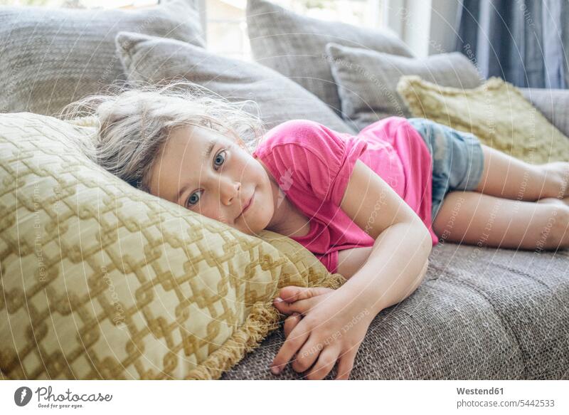 Portrait of girl lying on couch females girls settee sofa sofas couches settees relaxed relaxation laying down lie lying down child children kid kids people