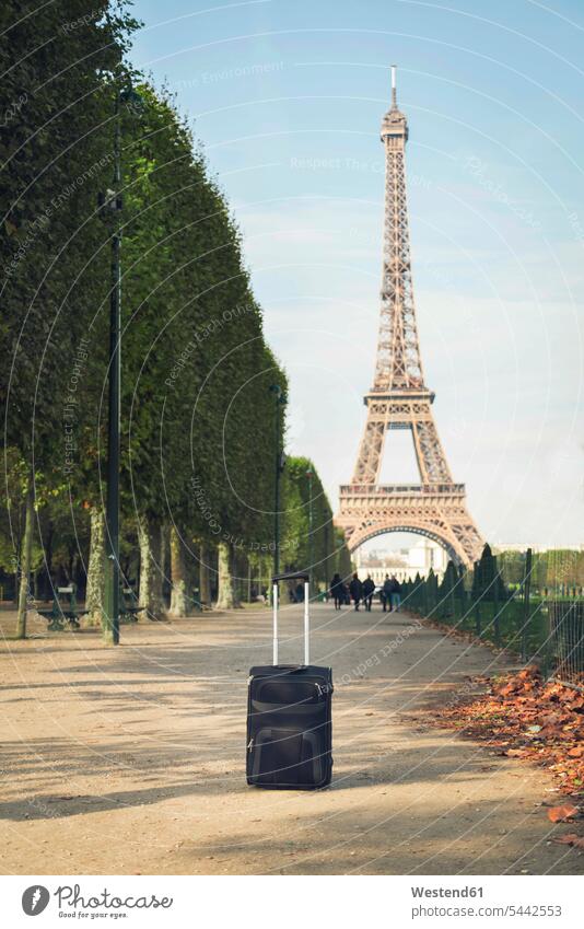 France, Paris, Champ de Mars, view to Eiffel Tower with trolley bag in the foreground copy space Ominous sinister menacing looming day daylight shot