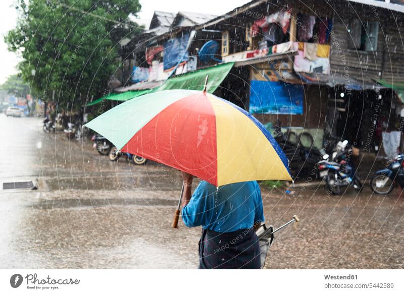 Myanmar, back view of man under umbrella in the rain wet wetness rear view view from the back day daylight shot daylight shots day shots daytime